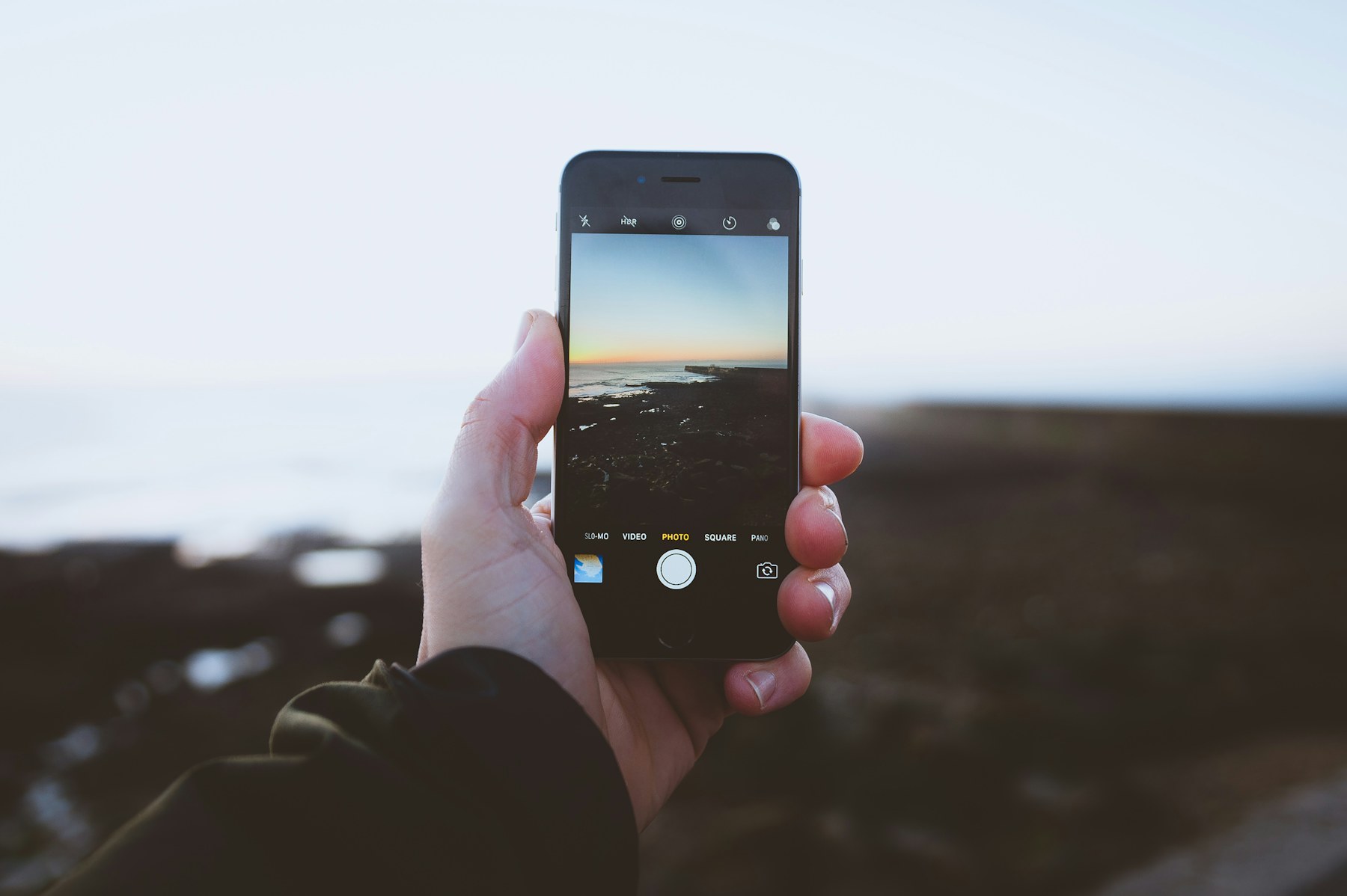 A person taking a landscape photo with an iPhone